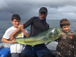 Captain miguel with two young guests posing with nice dorado caught fishing tuna coast
